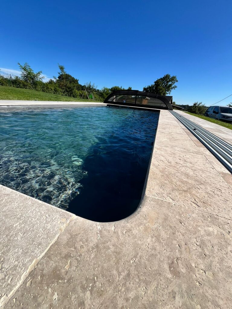 Piscine avec abri, liner gris anthracite, terrasse en travertin naturel, engazonnement