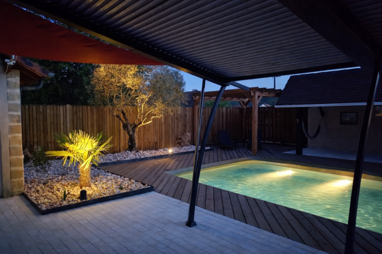 aménagement d'une terrasse en pavés et d'un tour de piscine en bois, massifs végétalisés, luminaires